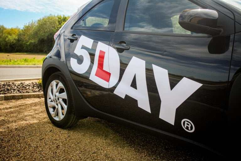 Up close of black car with 5day logo on the side