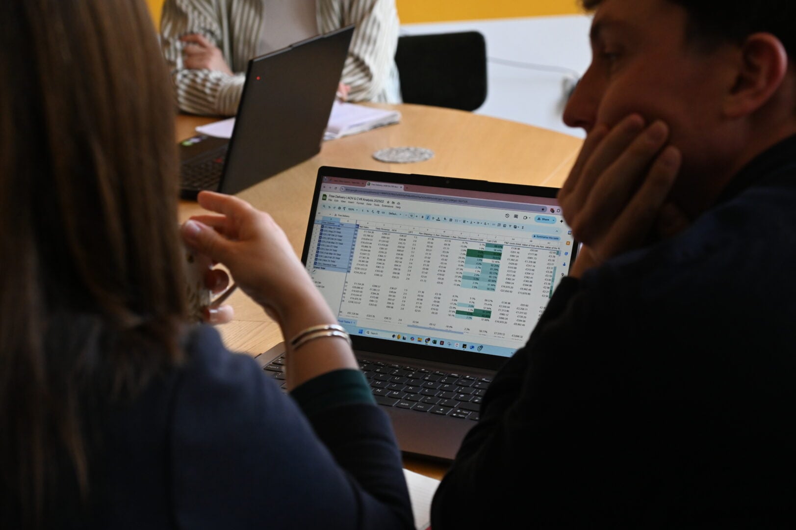 Rob and Jess reviewing reporting data together on a laptop