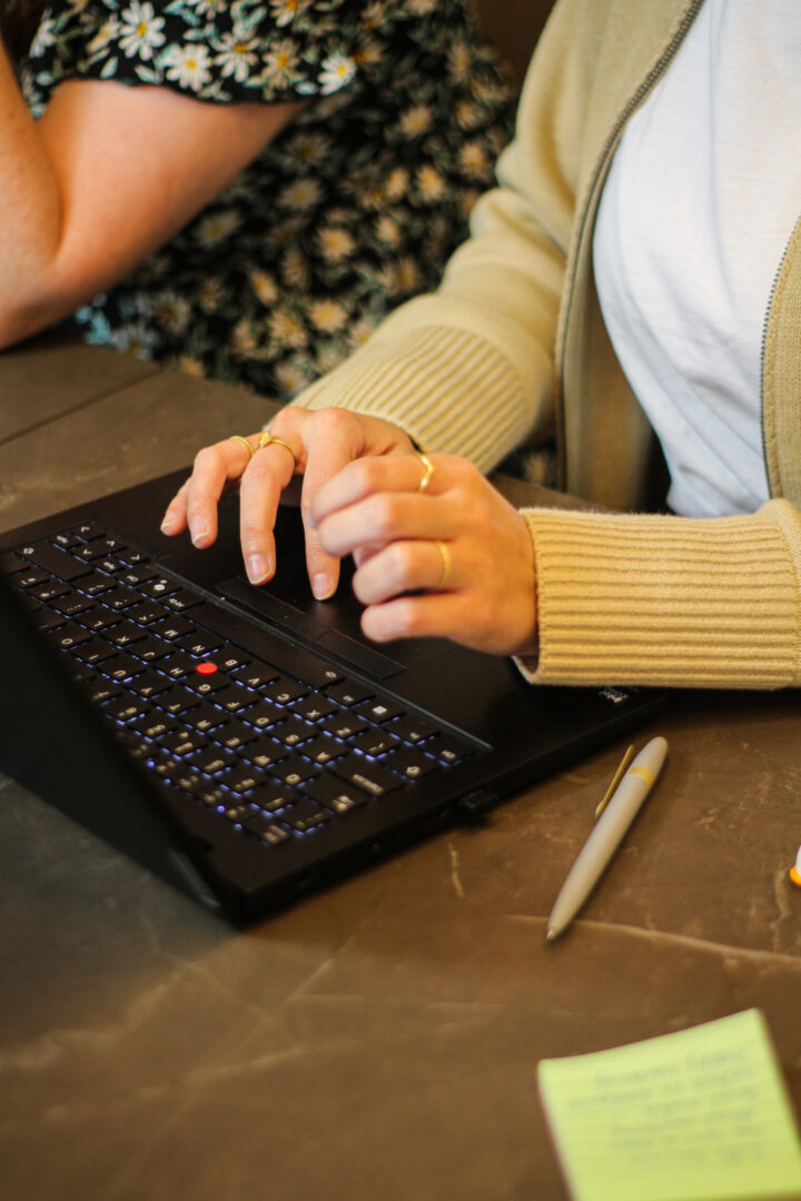 Up close of hands hovering over the keyboard of a black laptop