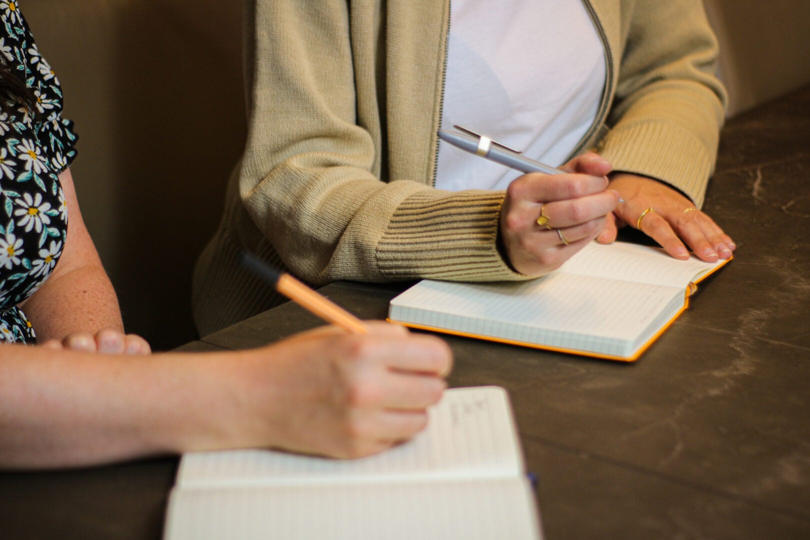 Hands writing in notebooks