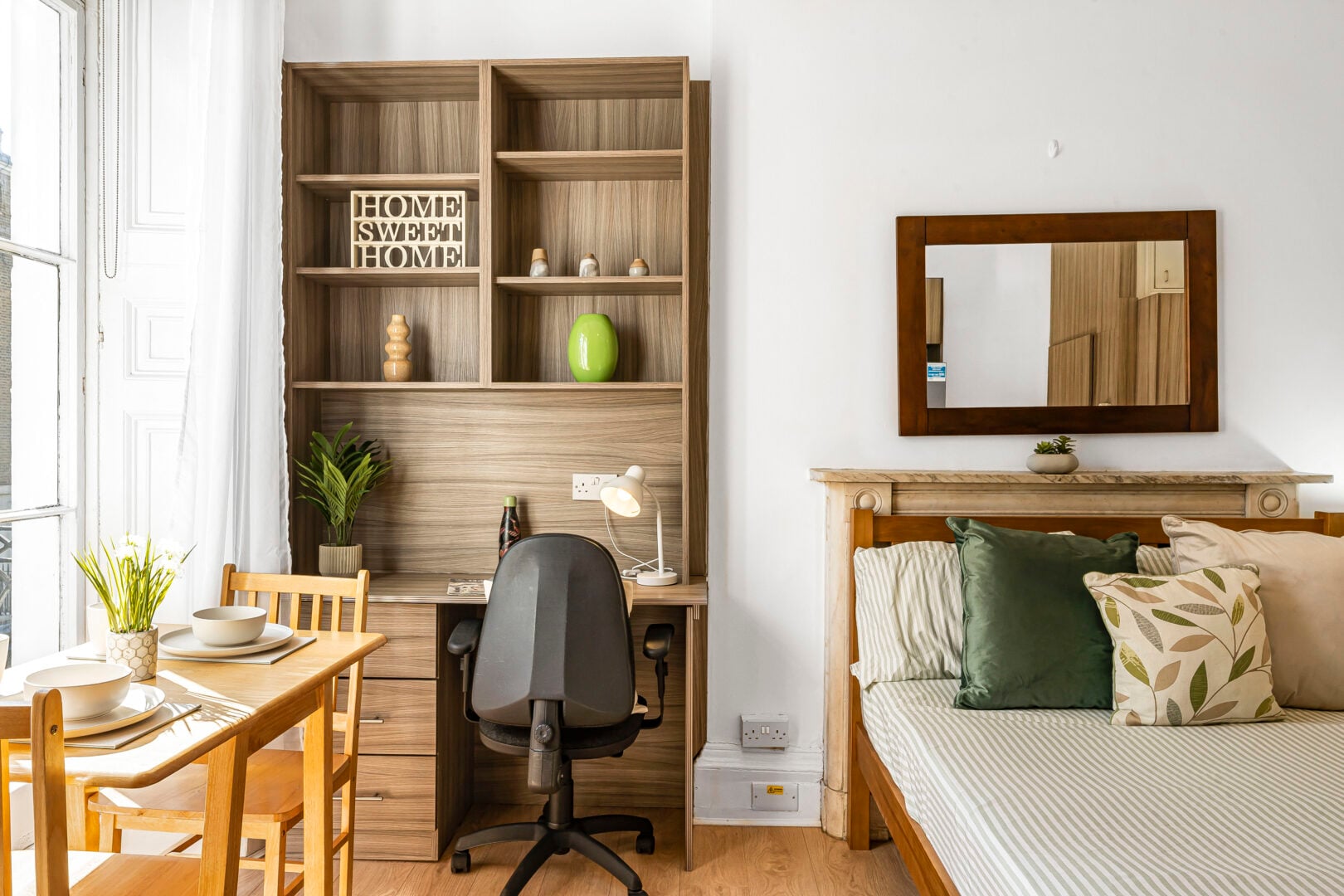 Interior of a student flat with bookcase, desk and bed
